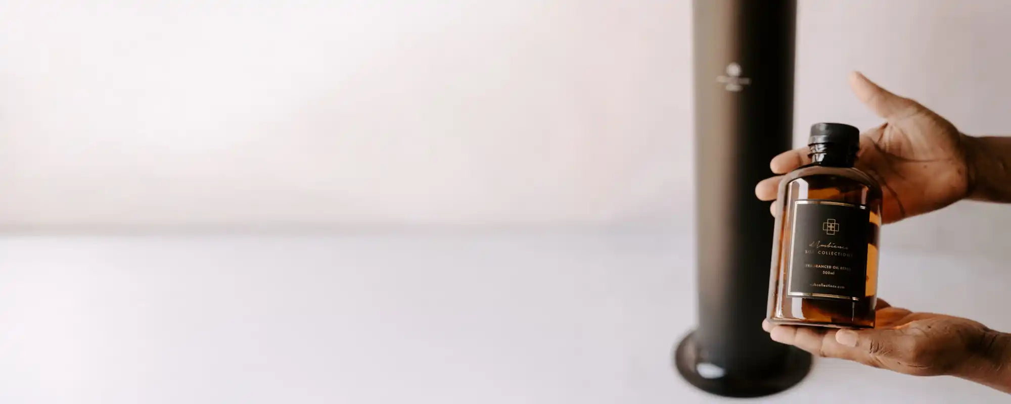 An amber glass bottle of fragrance with a black cap and label.