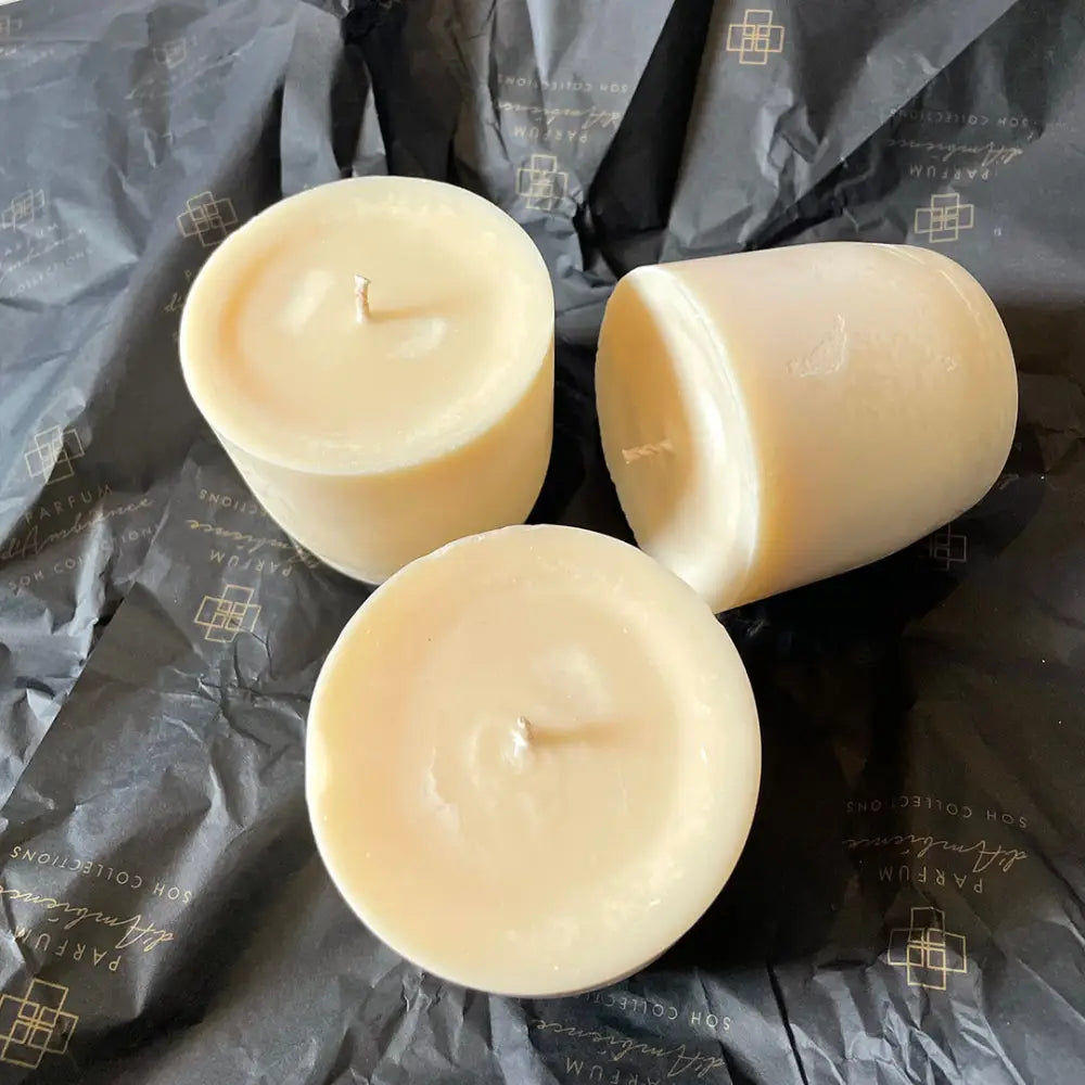 Eco Refill Candle Pod with three unlit light-colored cylindrical votive candles for diffuser use