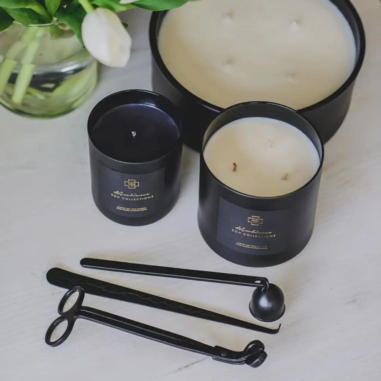 A set of black jar candles and candle accessories.