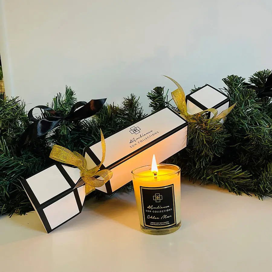 Lit yellow candle in clear glass jar from Festive Cracker scent diffuser collection