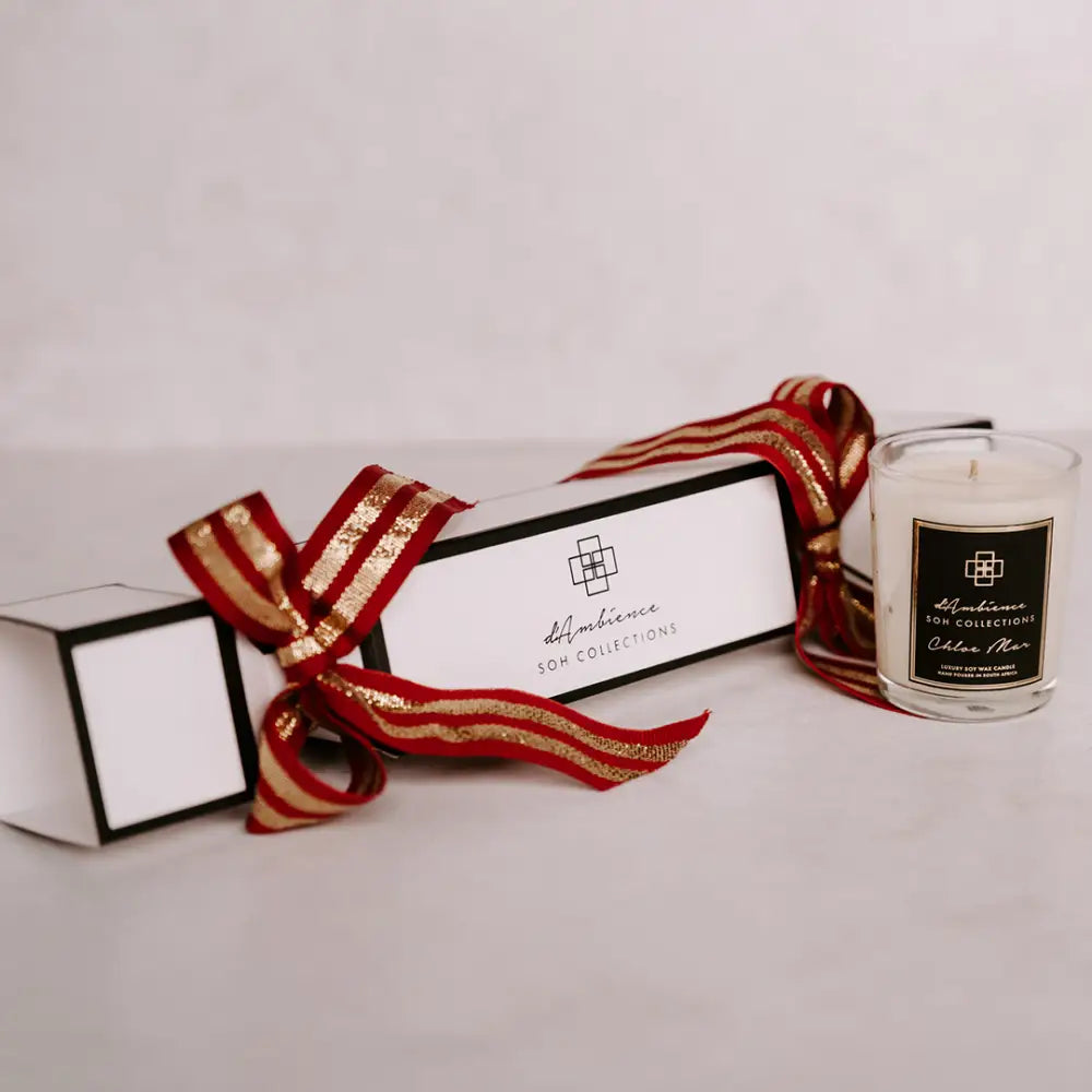 Festive Christmas cracker gift set with white box, red gold ribbon, and glass jar candle