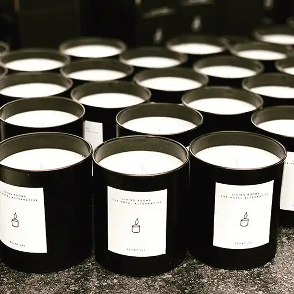 Rows of black jar candles with white wax.