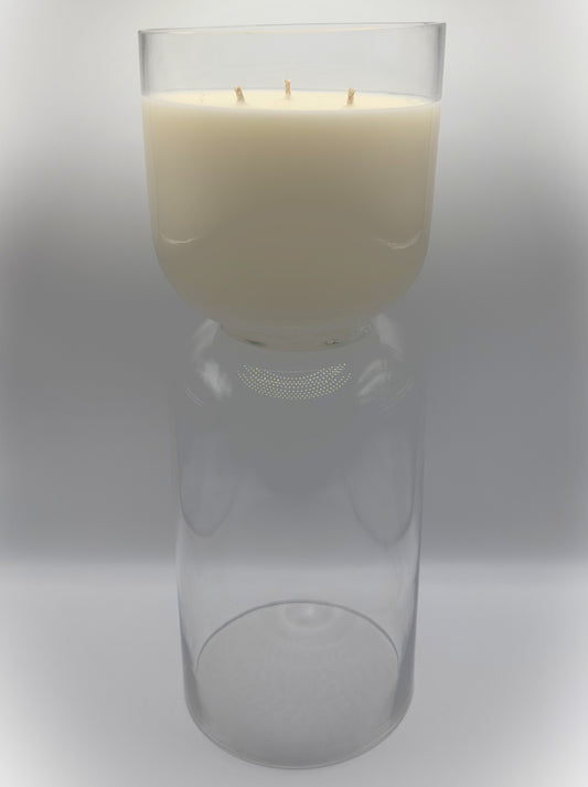 Tall hurricane glass grand candle with triple-wick cream-colored candle in clear hurricane glass