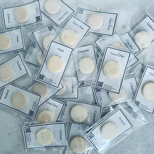 Individually packaged round off-white wax melts in a sample pack for diffuser scent diffusion
